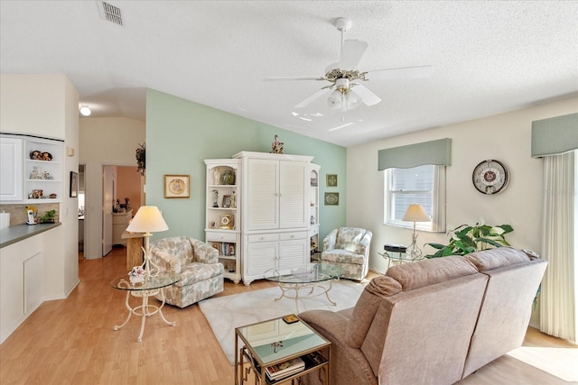 2121 Escobar Ave, Lady Lake, FL 32159 - living room with light wood-type flooring, ceiling fan, a textured ceiling, and vaulted ceiling