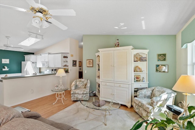 2121 Escobar Ave, Lady Lake, FL 32159 - living room featuring ceiling fan, light wood-type flooring, lofted ceiling, and a skylight