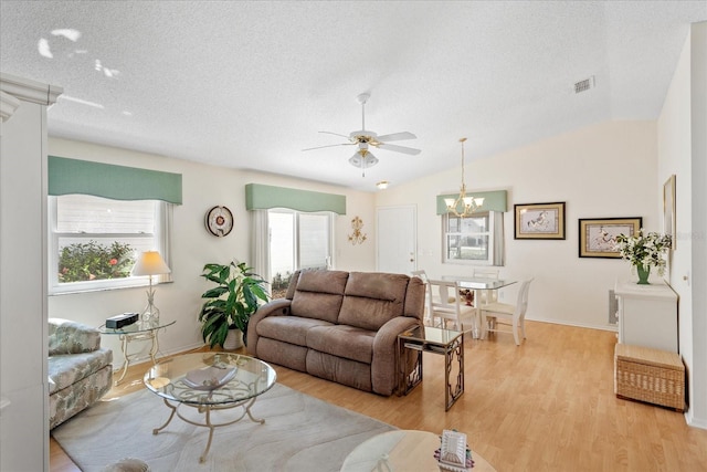 2121 Escobar Ave, Lady Lake, FL 32159 - living room featuring a ceiling fan, light wood finished floors, a textured ceiling, a chandelier, and baseboards