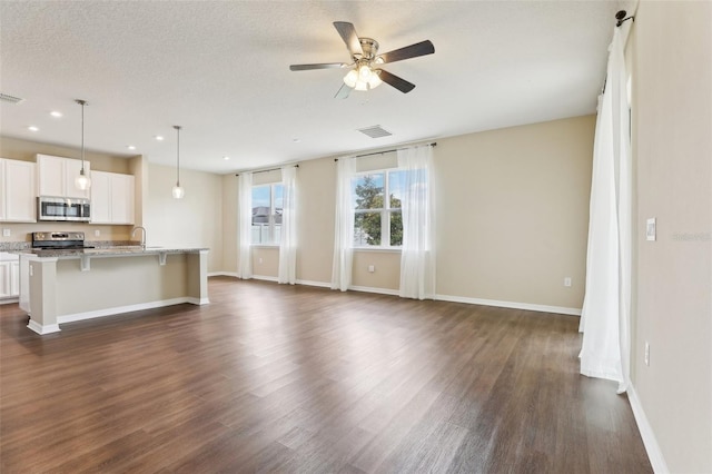 392 Summer Squall Rd, Davenport, FL 33837 - unfurnished living room featuring dark wood finished floors, baseboards, a ceiling fan, and recessed lighting