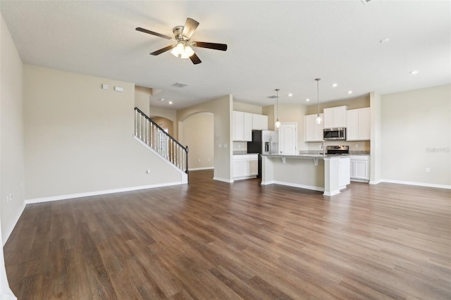 392 Summer Squall Rd, Davenport, FL 33837 - unfurnished living room featuring ceiling fan, wood finished floors, baseboards, stairway, and recessed lighting