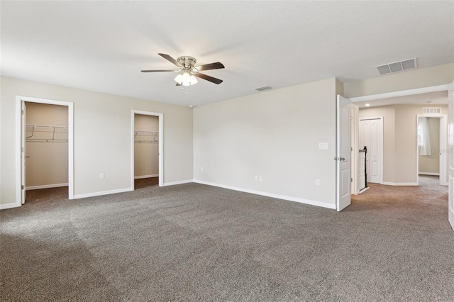 392 Summer Squall Rd, Davenport, FL 33837 - unfurnished bedroom featuring dark carpet, baseboards, multiple closets, and ceiling fan