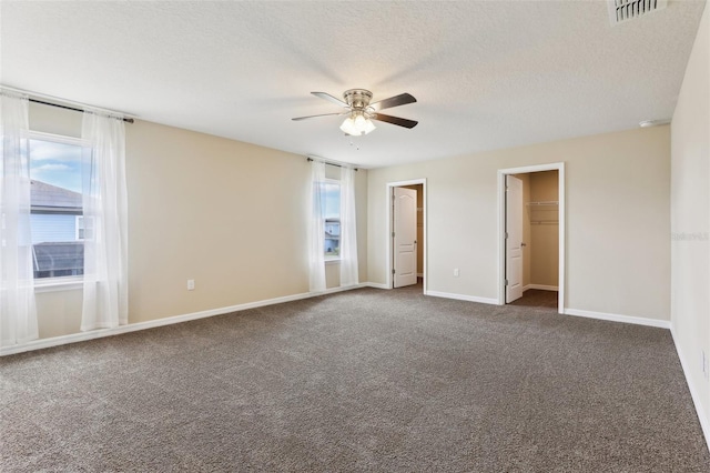 392 Summer Squall Rd, Davenport, FL 33837 - unfurnished bedroom featuring dark colored carpet, baseboards, a textured ceiling, a ceiling fan, and a spacious closet