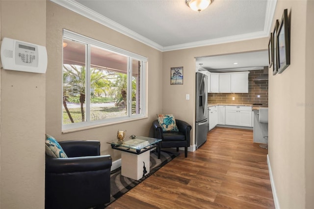 living room with ornamental molding and wood finished floors