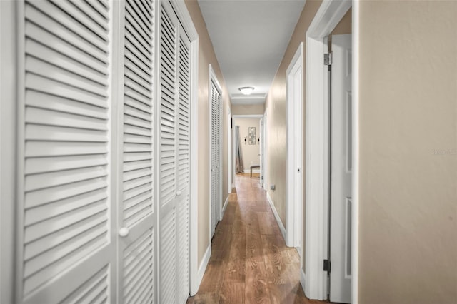 hallway with wood finished floors and baseboards