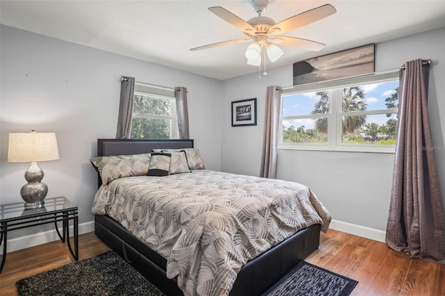 bedroom with wood finished floors, baseboards, and a ceiling fan