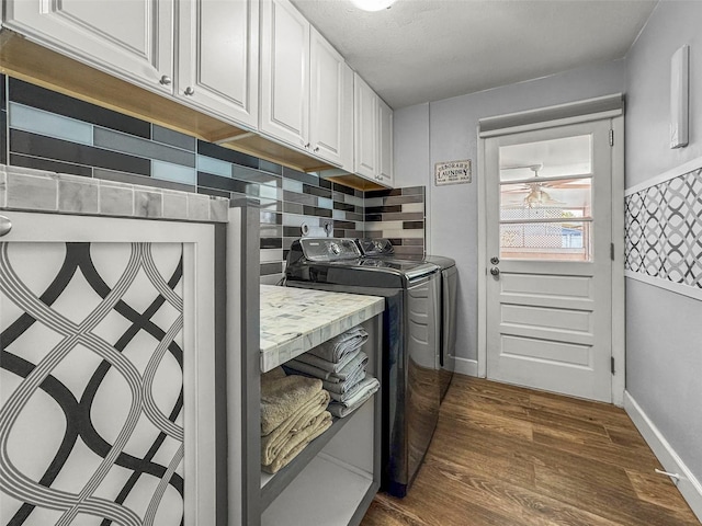 laundry area featuring cabinet space, separate washer and dryer, dark wood finished floors, a ceiling fan, and baseboards