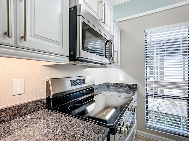 2695 N Seabreeze Pt Unit I1, Crystal River, FL 34429 - kitchen featuring appliances with stainless steel finishes, white cabinets, and dark stone counters