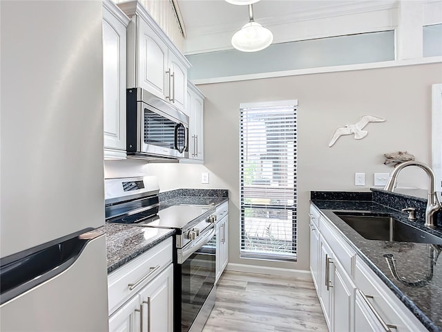2695 N Seabreeze Pt Unit I1, Crystal River, FL 34429 - kitchen featuring appliances with stainless steel finishes, a sink, dark stone countertops, light wood-style floors, and white cabinets