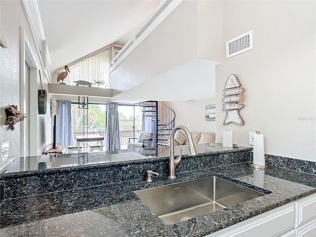 2695 N Seabreeze Pt Unit I1, Crystal River, FL 34429 - kitchen featuring a sink, dark stone countertops, open floor plan, white cabinetry, and a high ceiling