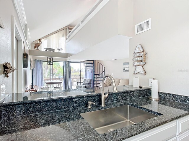 2695 N Seabreeze Pt Unit I1, Crystal River, FL 34429 - kitchen featuring a sink, dark stone countertops, open floor plan, white cabinetry, and a high ceiling