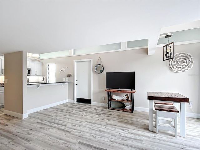 2695 N Seabreeze Pt Unit I1, Crystal River, FL 34429 - unfurnished living room featuring light wood-style flooring, baseboards, and a sink