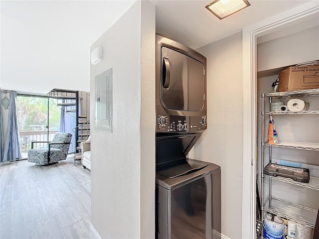 2695 N Seabreeze Pt Unit I1, Crystal River, FL 34429 - laundry area with stacked washing machine and dryer, electric panel, wood finished floors, baseboards, and a textured wall