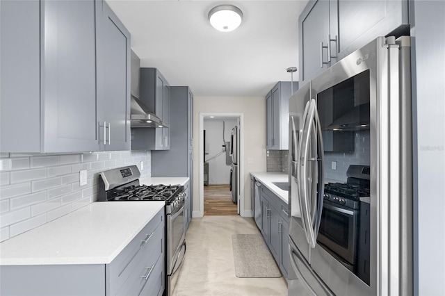 1489 77th Ave N, Saint Petersburg, FL 33702 - kitchen with stainless steel range with gas stovetop, wall chimney exhaust hood, gray cabinetry, and tasteful backsplash