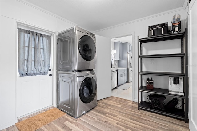 1489 77th Ave N, Saint Petersburg, FL 33702 - laundry room featuring stacked washer and clothes dryer, crown molding, and light wood-style floors