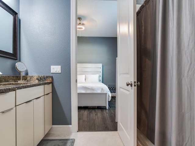 16220 Lake Armistead Way, Odessa, FL 33556 - bathroom featuring wood finished floors, ensuite bath, vanity, a textured wall, and baseboards