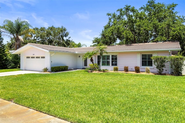 single story home featuring a garage, a front yard, a tiled roof, and concrete driveway