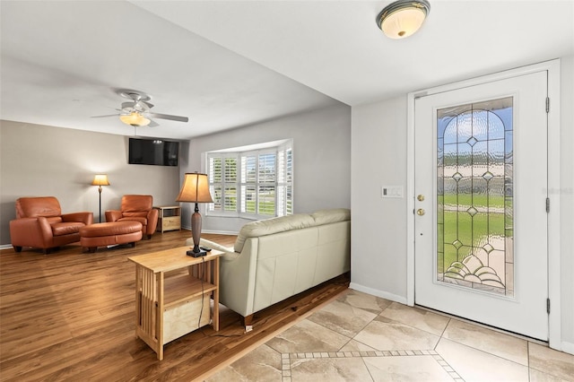 foyer with ceiling fan, baseboards, and wood finished floors