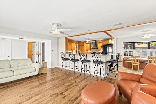 living room featuring ceiling fan and light wood-style floors