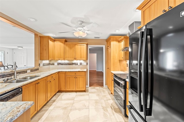 kitchen with stainless steel appliances, a sink, a ceiling fan, light stone counters, and tasteful backsplash