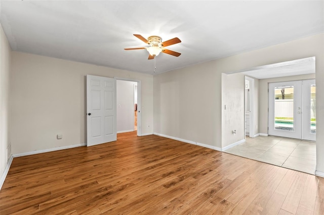 empty room featuring light wood-style flooring, a ceiling fan, and baseboards