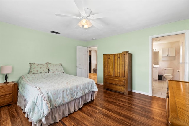 bedroom featuring wood finished floors, baseboards, ensuite bath, and a ceiling fan
