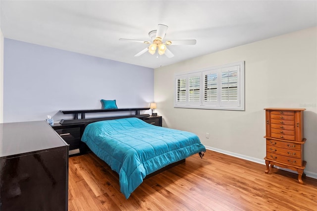 bedroom featuring wood finished floors, baseboards, and ceiling fan