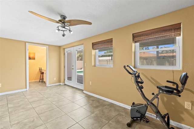 workout area featuring a ceiling fan, french doors, baseboards, and light tile patterned floors