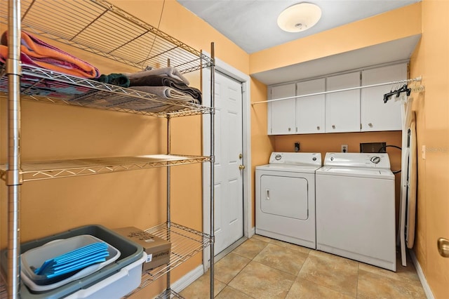 laundry room with cabinet space, washer and dryer, and light tile patterned floors