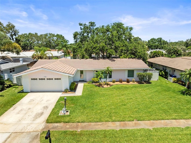 ranch-style home with a tiled roof, a front yard, concrete driveway, and an attached garage