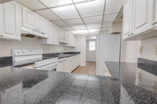 kitchen with white appliances, under cabinet range hood, a sink, white cabinetry, and light wood-type flooring