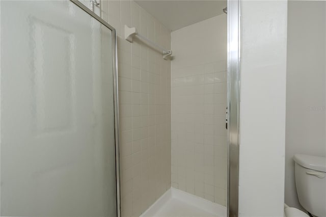 full bath with a stall shower and toilet