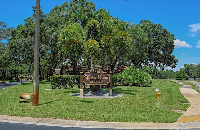 surrounding community featuring a lawn and view of wooded area