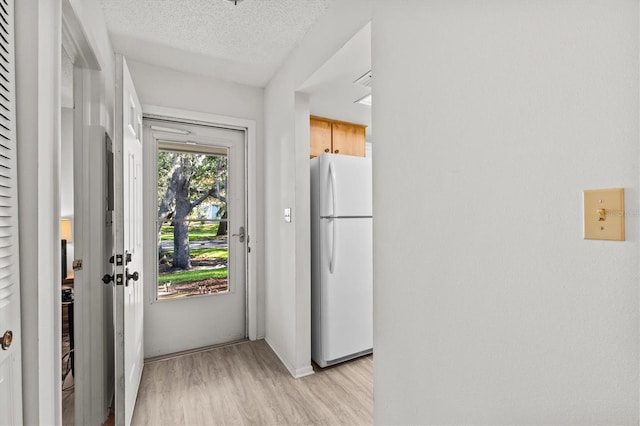 39650 US Highway 19 N Unit 553, Tarpon Springs, FL 34689 - doorway to outside with light wood-type flooring, a textured ceiling, and baseboards