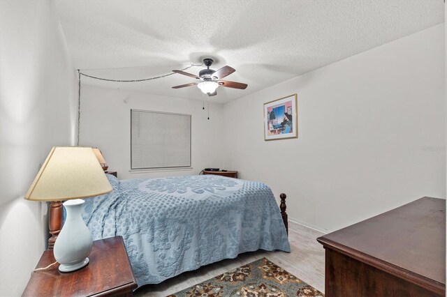 39650 US Highway 19 N Unit 553, Tarpon Springs, FL 34689 - bedroom featuring wood finished floors, a textured ceiling, baseboards, and ceiling fan