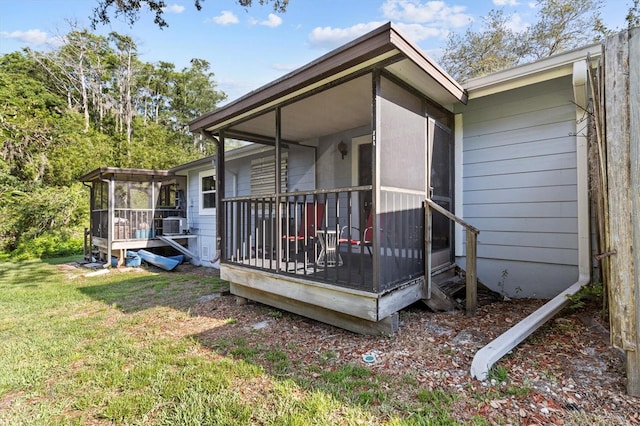 39650 US Highway 19 N Unit 553, Tarpon Springs, FL 34689 - view of side of home featuring a sunroom, a lawn, central air condition unit, and a wooden deck
