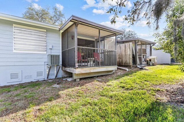 39650 US Highway 19 N Unit 553, Tarpon Springs, FL 34689 - rear view of house featuring a sunroom, a yard, and central AC unit