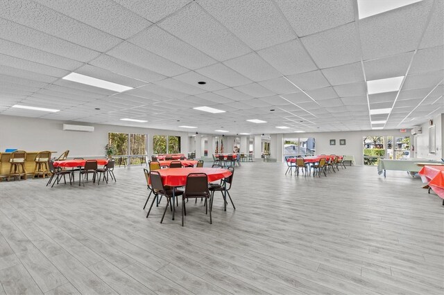 39650 US Highway 19 N Unit 553, Tarpon Springs, FL 34689 - dining room featuring a paneled ceiling, a wall mounted AC, and light wood-style flooring