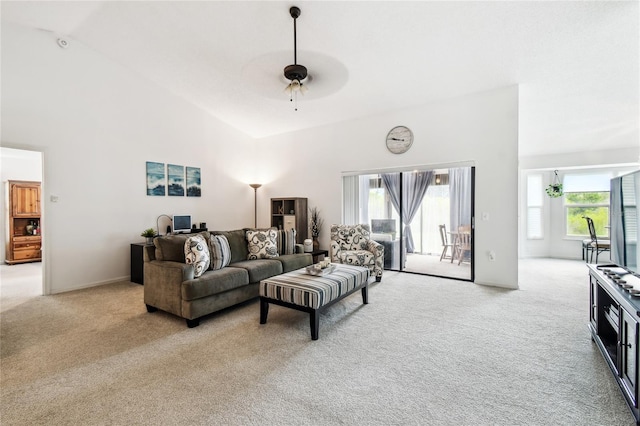 living area featuring light colored carpet, a ceiling fan, and high vaulted ceiling