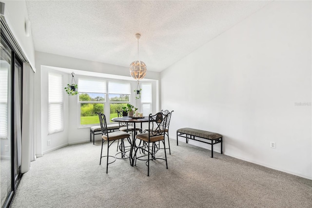 dining room with carpet, a textured ceiling, a chandelier, and baseboards