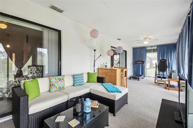 carpeted living room featuring a ceiling fan