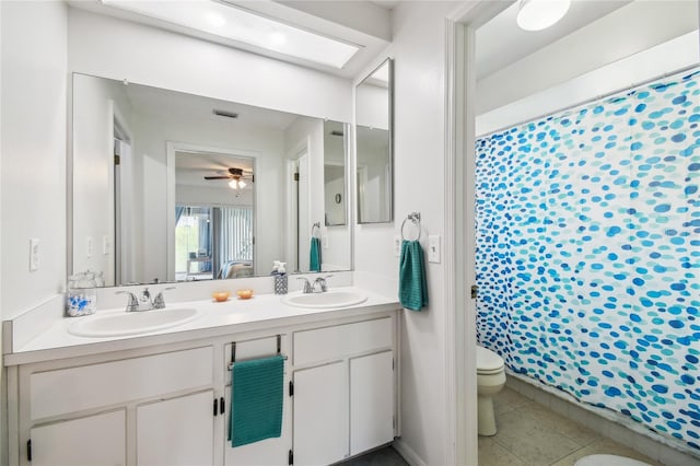 full bathroom featuring toilet, double vanity, a ceiling fan, and a shower with curtain
