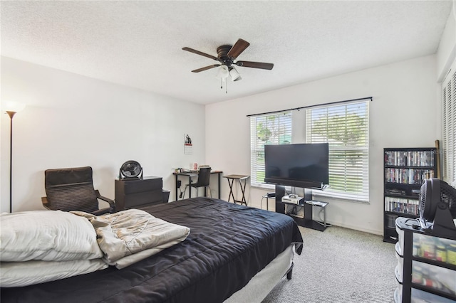 carpeted bedroom with a textured ceiling, ceiling fan, and baseboards
