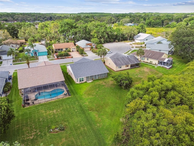 aerial view of residential area with a pool area and a heavily wooded area