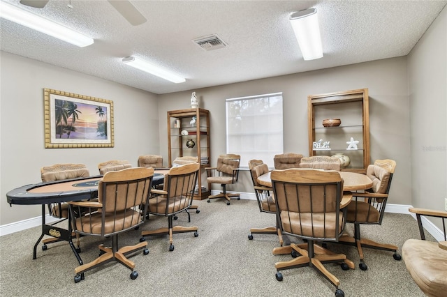 carpeted dining room featuring baseboards and a textured ceiling