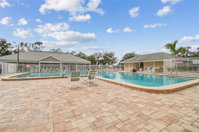 community pool featuring fence and a patio