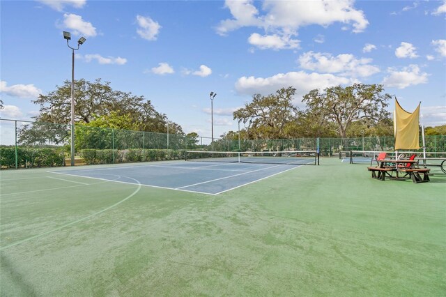 view of tennis court with fence and community basketball court