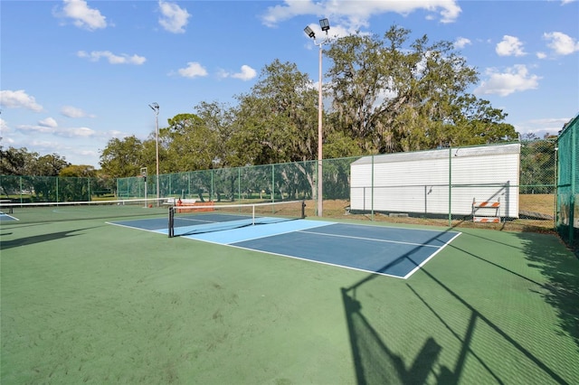 view of tennis court with fence and community basketball court