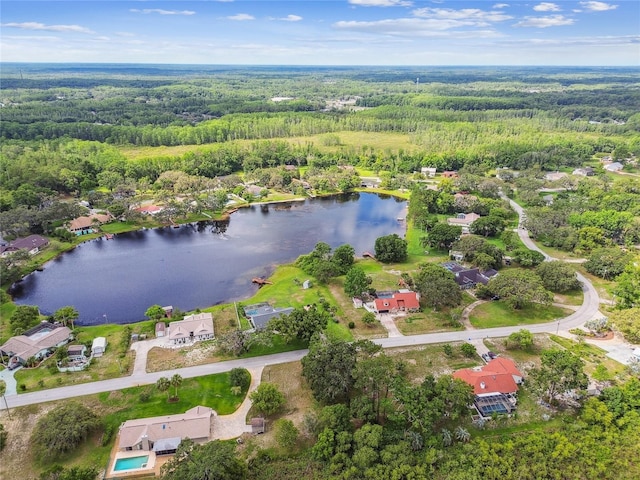 aerial view of property's location with a forest and a large body of water