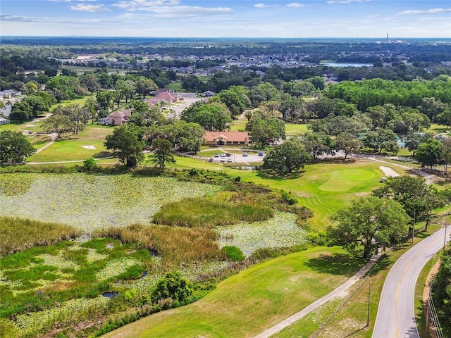 view of property location with a golf course and a tree filled landscape